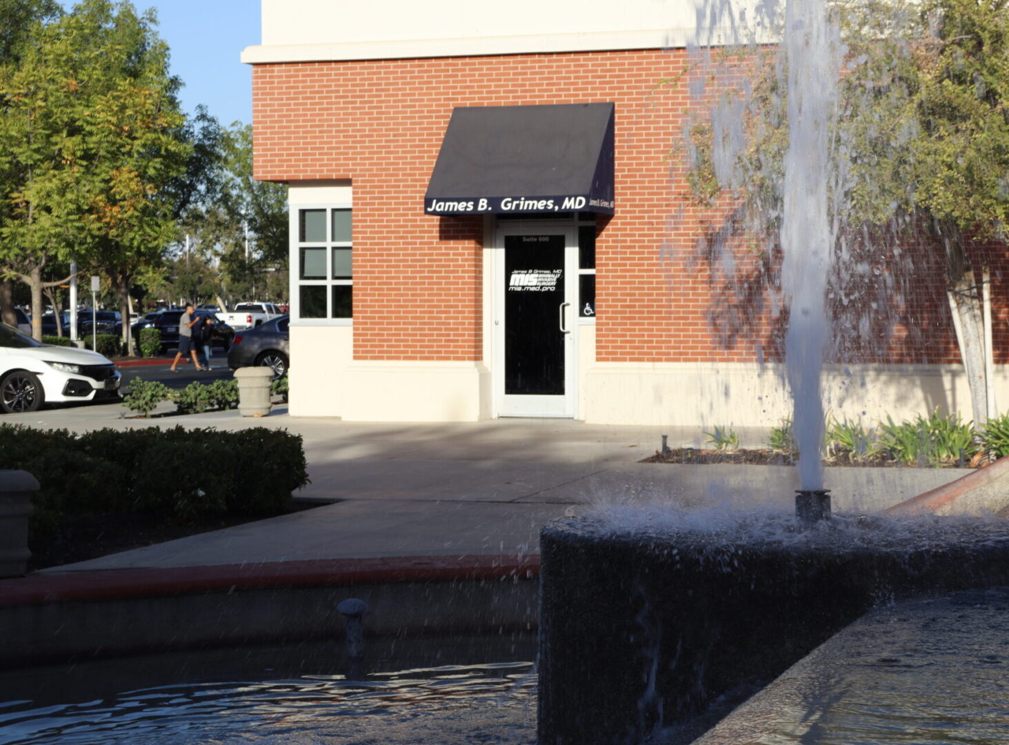 Entrance to office is near the fountain.